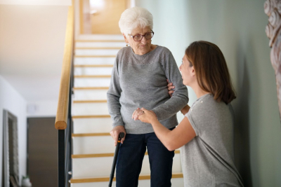 caregiver helping senior woman get down on the stairs